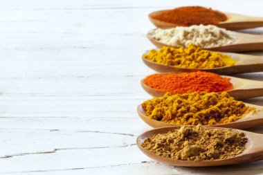 tahta kaşıklar sıkıntılı Beyaz ahşap üzerine olarak baharat