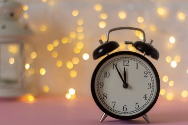 Bokehle birlikte bulanık bir arkaplanda siyah çalar saat. Yeni yıl konsepti, boşluğun bir kopyası..