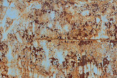Paslı mavi metal bir duvar, düşmüş bir boya, paslı bir arka plan..