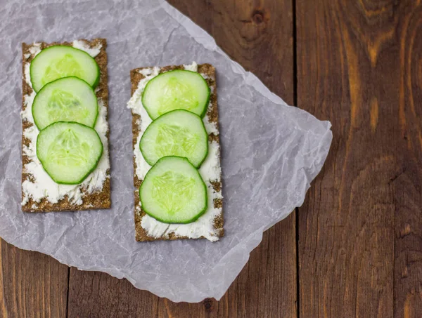 Çavdar ekmeği, süzme peynir ve arka planda taze salatalık. Diyet sandviç.