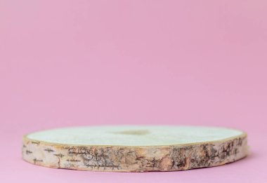 Sunumlar için doğal ahşaptan yapılmış podyum ve pembe bir arkaplan üzerine sergiler. Kopyalamak için alan