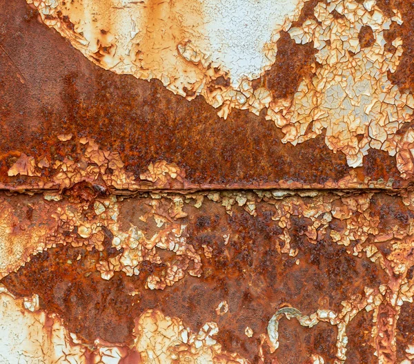 Paslı mavi metal bir duvar, düşmüş bir boya, paslı bir arka plan.