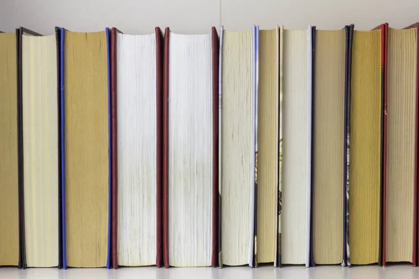 Livros.Vários livros estão em uma fileira em uma prateleira ou em um armário. — Fotografia de Stock