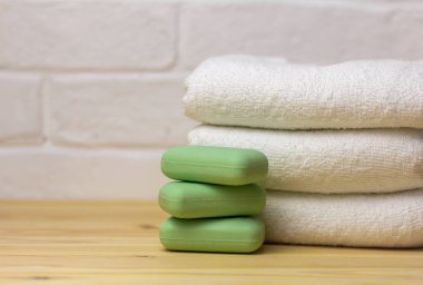 Masada bir yığın temiz beyaz havlu ve sabun var..