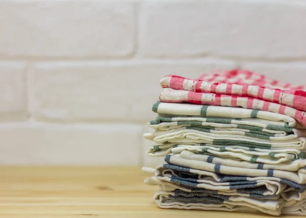 Una pila de toallas de cocina limpias sobre la mesa. —  Fotos de Stock