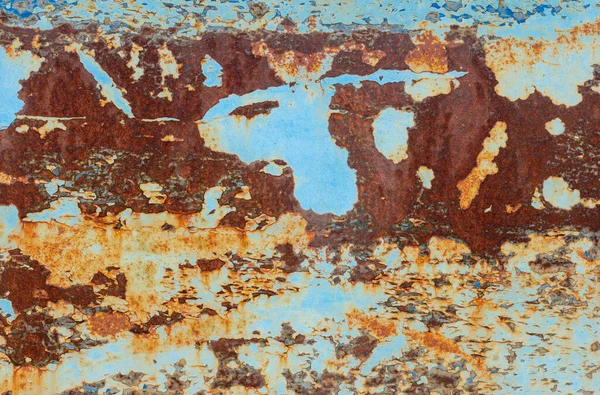 Een roestige blauwe metalen muur met gevallen verf, een roestige ondergrond. — Stockfoto