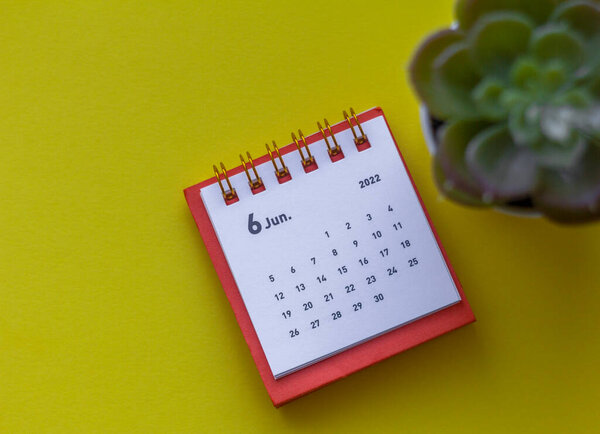 Desktop calendar for June 2022 on a yellow background