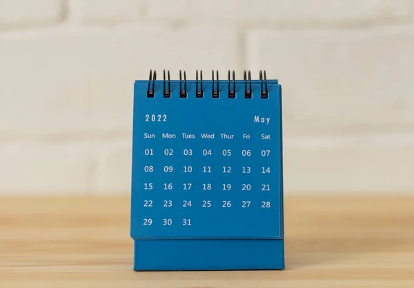 Desktop blue calendar for May 2022 on the table