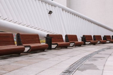 Şehir meydanındaki modern banklar. Şehir gelişimi, şehir planlaması, kamusal alanlar, modern şehir tasarımı