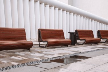 Şehir meydanındaki modern banklar. Şehir gelişimi, şehir planlaması, kamusal alanlar, modern şehir tasarımı