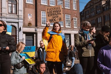 Hollanda, Amsterdam, 27.02.2022 Ukrayna 'da savaşa karşı bir gösteri. Rusya 'nın Ukrayna' yı işgaline karşı protesto. Savaş karşıtı şarkılar, pankartlar, pankartlar, Ukrayna bayrağı