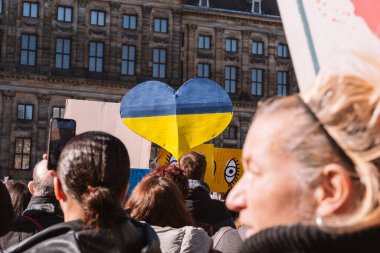 Hollanda, Amsterdam, 27.02.2022 Ukrayna 'da savaşa karşı bir gösteri. Rusya 'nın Ukrayna' yı işgaline karşı protesto. Savaş karşıtı şarkılar, pankartlar, pankartlar, Ukrayna bayrağı