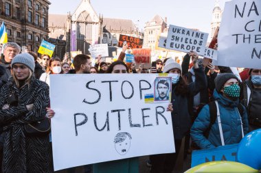 Hollanda, Amsterdam, 27.02.2022 Ukrayna 'da savaşa karşı bir gösteri. Rusya 'nın Ukrayna' yı işgaline karşı protesto. Savaş karşıtı şarkılar, pankartlar, pankartlar, Ukrayna bayrağı