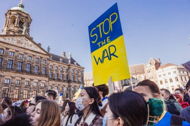 Hollanda, Amsterdam, 27.02.2022 Ukrayna 'da savaşa karşı bir gösteri. Rusya 'nın Ukrayna' yı işgaline karşı protesto. Savaş karşıtı şarkılar, pankartlar, pankartlar, Ukrayna bayrağı