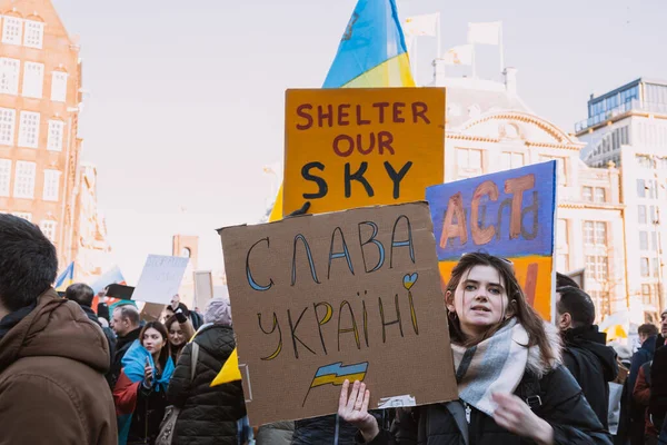 Hollanda, Amsterdam, 27.02.2022 Ukrayna 'da savaşa karşı bir gösteri. Rusya 'nın Ukrayna' yı işgaline karşı protesto. Savaş karşıtı şarkılar, pankartlar, pankartlar, Ukrayna bayrağı