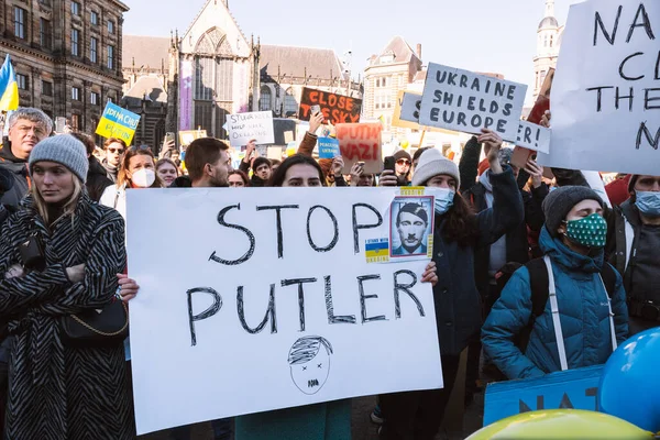 Hollanda, Amsterdam, 27.02.2022 Ukrayna 'da savaşa karşı bir gösteri. Rusya 'nın Ukrayna' yı işgaline karşı protesto. Savaş karşıtı şarkılar, pankartlar, pankartlar, Ukrayna bayrağı