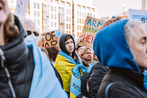 Hollanda, Amsterdam, 27.02.2022 Ukrayna 'da savaşa karşı bir gösteri. Rusya 'nın Ukrayna' yı işgaline karşı protesto. Savaş karşıtı şarkılar, pankartlar, pankartlar, Ukrayna bayrağı