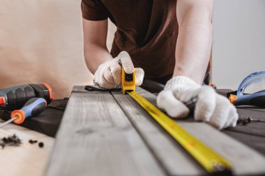 Onarım, bina ve ev konsepti - erkek eli ahşap ölçer. Profesyonel marangoz sarı mezura ve kalemle doğru ölçümler yapar. Joinery araçları