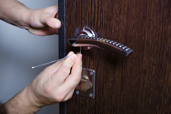 Locksmith replacing door lock to new after losing keys. Robbery protection, safety improvement. Csose up hands of Repairman or workman changing or repair door lock by screwdriver hex