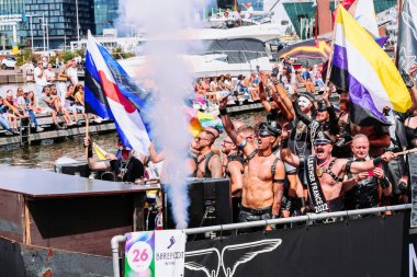 Pride Parade of lesbian, gay, bisexual, transgender, queer and allies. Mans in leather costumes with pansexual, non-binary and Gay leather pride flags - Netherlands, Amsterdam, August 6, 2022