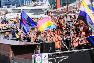 Pride Parade of lesbian, gay, bisexual, transgender, queer and allies. Mans in leather costumes with pansexual, non-binary and Gay leather pride flags - Netherlands, Amsterdam, August 6, 2022