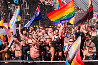 Pride Parade of lesbian, gay, bisexual, transgender, queer and allies. People s in leather bondage costumes with Gay leather and LGBT Pride flags - Netherlands, Amsterdam, August 6, 2022