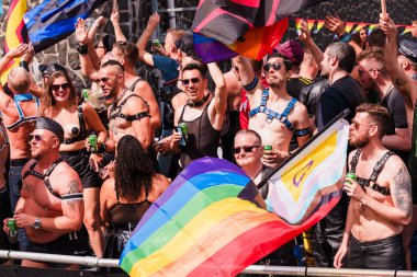 Pride Parade of lesbian, gay, bisexual, transgender, queer and allies. People s in leather bondage costumes with Gay leather and LGBT Progress Pride flags - Netherlands, Amsterdam, August 6, 2022