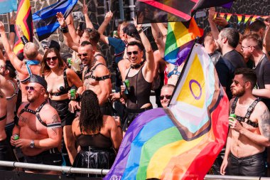 Pride Parade of lesbian, gay, bisexual, transgender, queer and allies. People s in leather bondage costumes with Gay leather and LGBT Progress Pride flags - Netherlands, Amsterdam, August 6, 2022