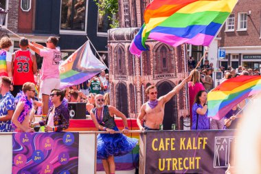 People in carnival costumes with lgbt pride flag - lesbian, gay, bisexual, transgender, queer Pride Parade in Amsterdam, Netherlands - August 6, 2022.