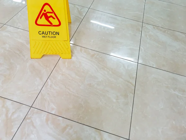 Wet floor with caution slippery sign. Incident warning. Office worker safety