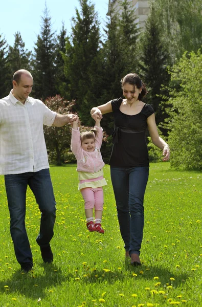 Familjen går i sommar park — Stockfoto