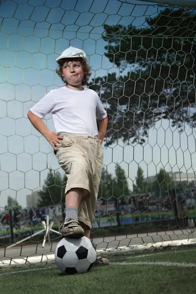 Мальчик с мячом в воротах — стоковое фото