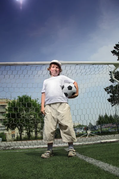Мальчик с мячом в воротах — стоковое фото