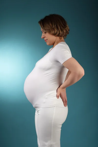 Beauty pregnancy studio session on blue — Stock Photo, Image