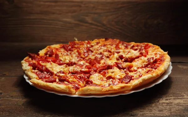 Круглая пицца на деревянном фоне — стоковое фото