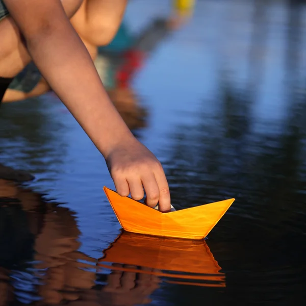 Barco de papel en la mano de niños — Foto de Stock