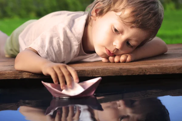 Barco de papel en la mano de niños — Foto de Stock