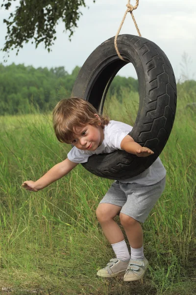 Happy boy on swing outdoors — Stock Photo, Image