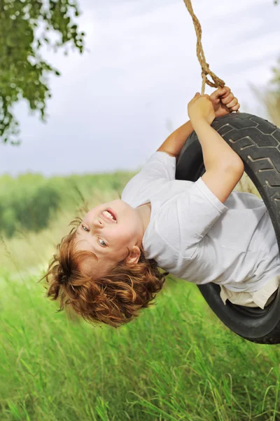 Açık havada salıncak üzerinde mutlu çocuk — Stok fotoğraf