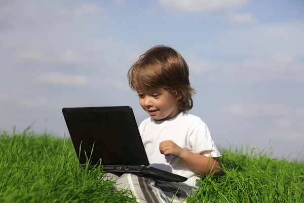 Happy boy with laptop outdoors Stock Picture