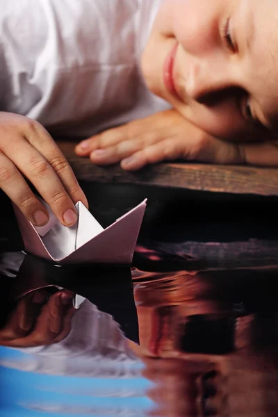 Паперовий корабель у дитячій руці — стокове фото