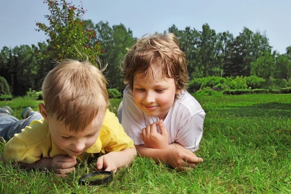 Dos chicos con lupa al aire libre — Foto de Stock