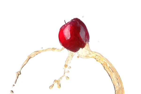 Червоне яблуко в потоці соку — стокове фото