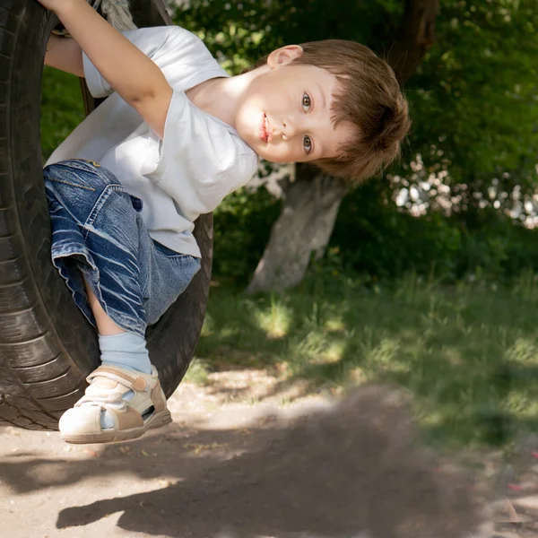 Happy boy on swing outdoors — Stock Photo, Image