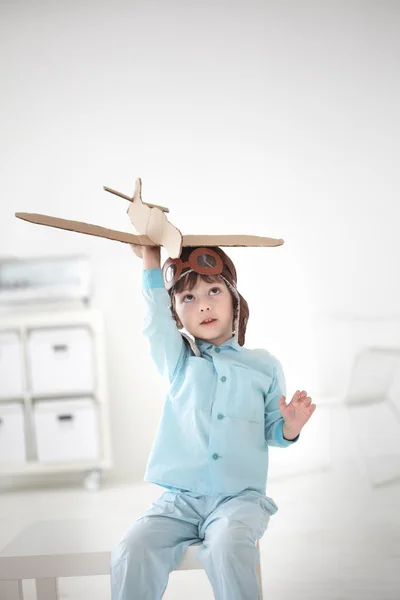 Szczęśliwy chłopiec grać w pomieszczeniu samolotem — Zdjęcie stockowe