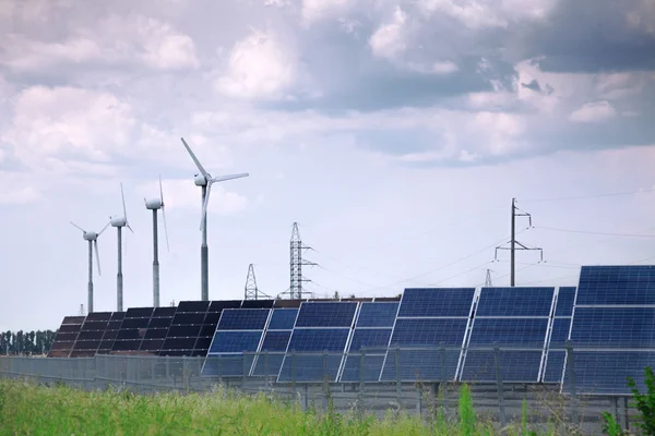Skutečné solární panely a větrný mlýn — Stock fotografie