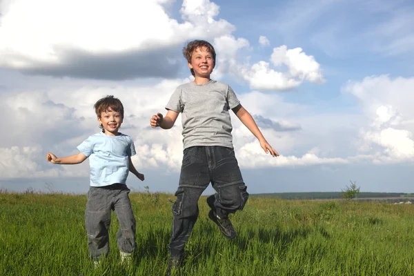 Мальчики бегают по зеленому полю — стоковое фото