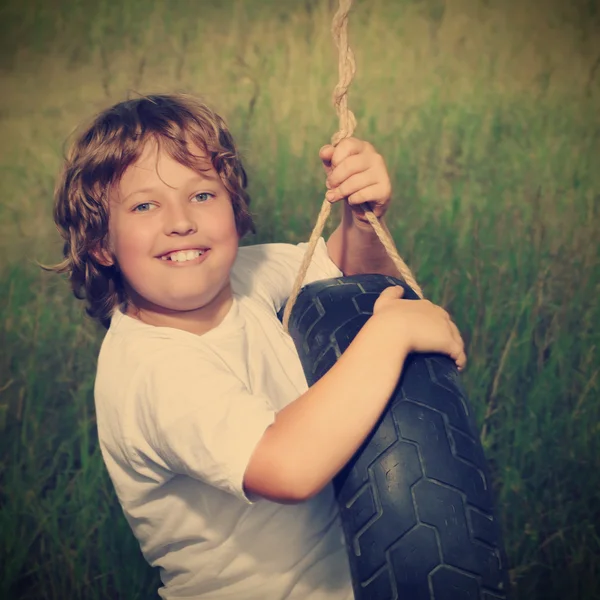 Happy boy on swing outdoors — Stock Photo, Image