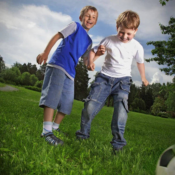 Dois menino feliz jogar no futebol — Fotografia de Stock