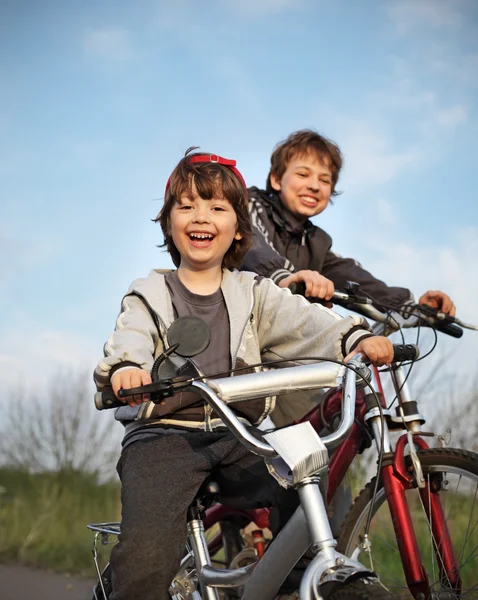İki kardeş bisiklet sürmek — Stok fotoğraf